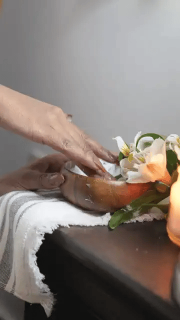 A woman in a white robe smoothing body butter onto her neck